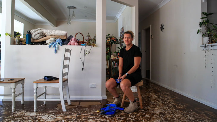 TAREE, AUSTRALIA - MAY 24: Linda Saundercock poses at her flooded second-floor home at Glenthorne on May 24, 2025 in Taree, Australia. Catastrophic floods have recently struck New South Wales, with more than 10,000 homes damaged, at least five people dead