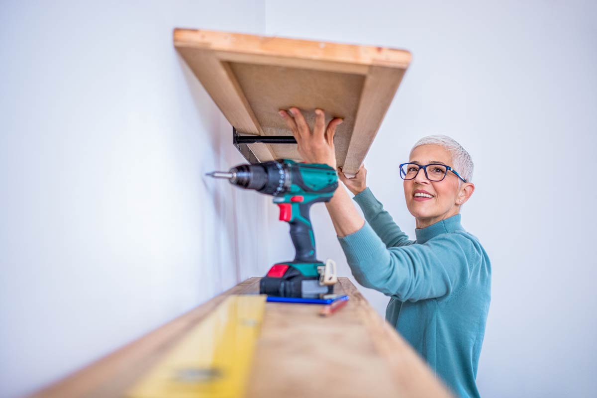 Woman using a cordless drill, an example of tools available to borrow for free from Australian libraries